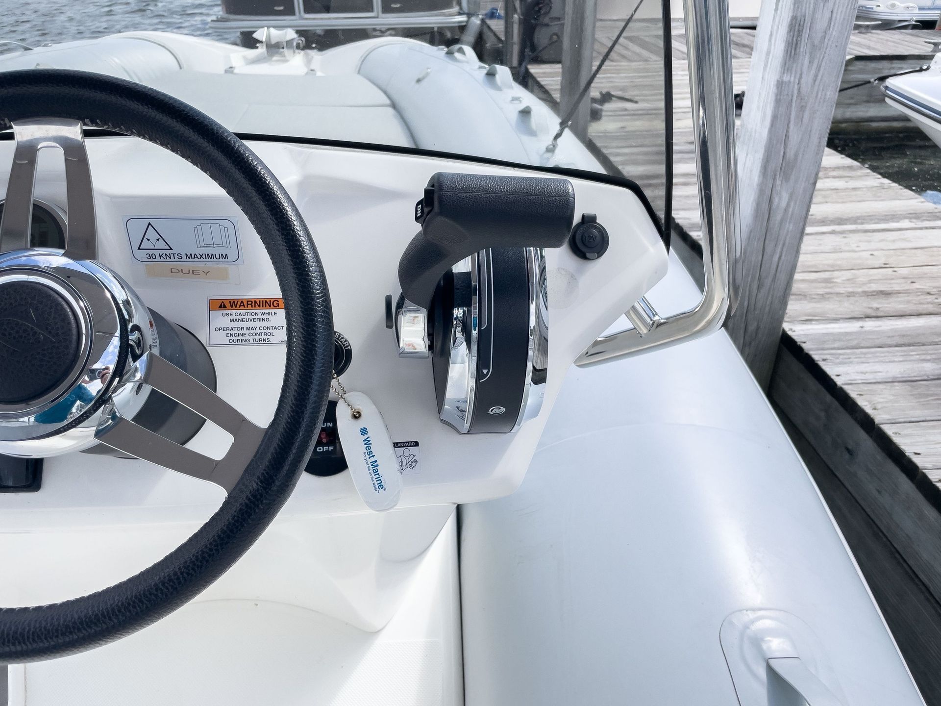 A white boat with a steering wheel and controls
