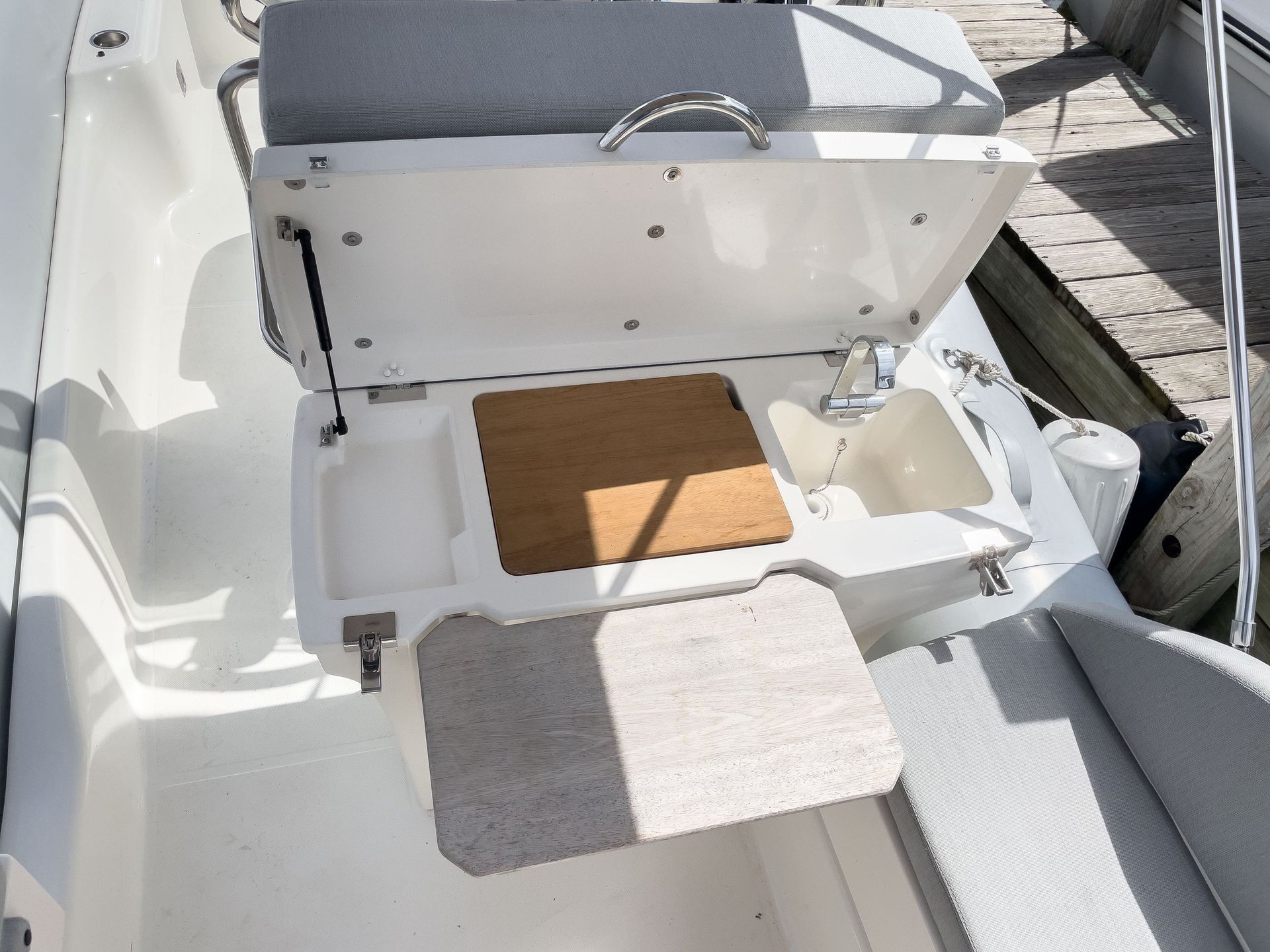 A boat with a sink and a cooler on the side of it.