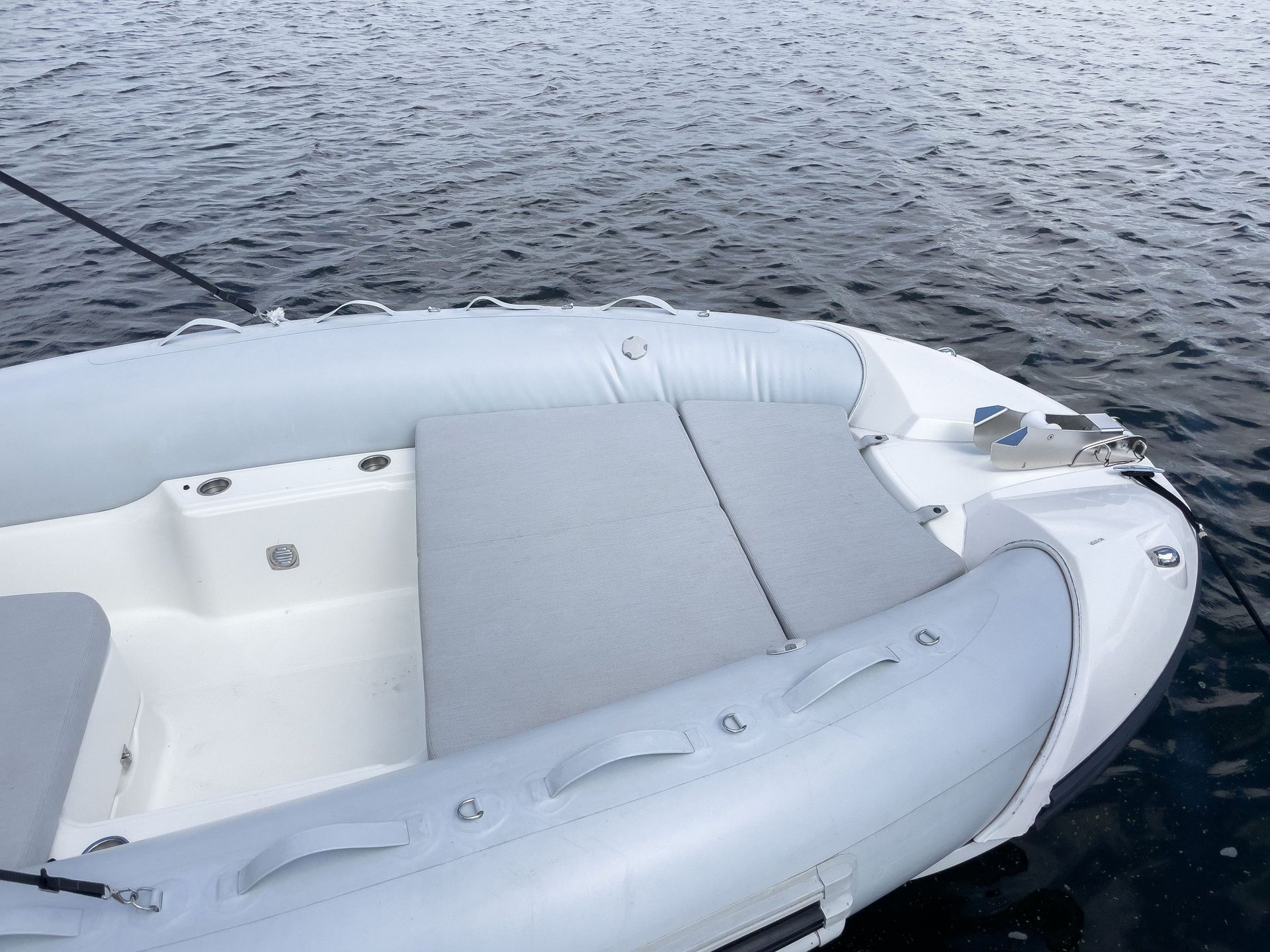 A white boat is floating on top of a body of water.