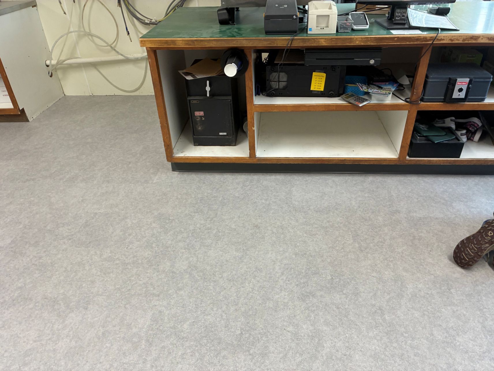 Office cubby shelves with electronics and cables beside a carpeted floor
