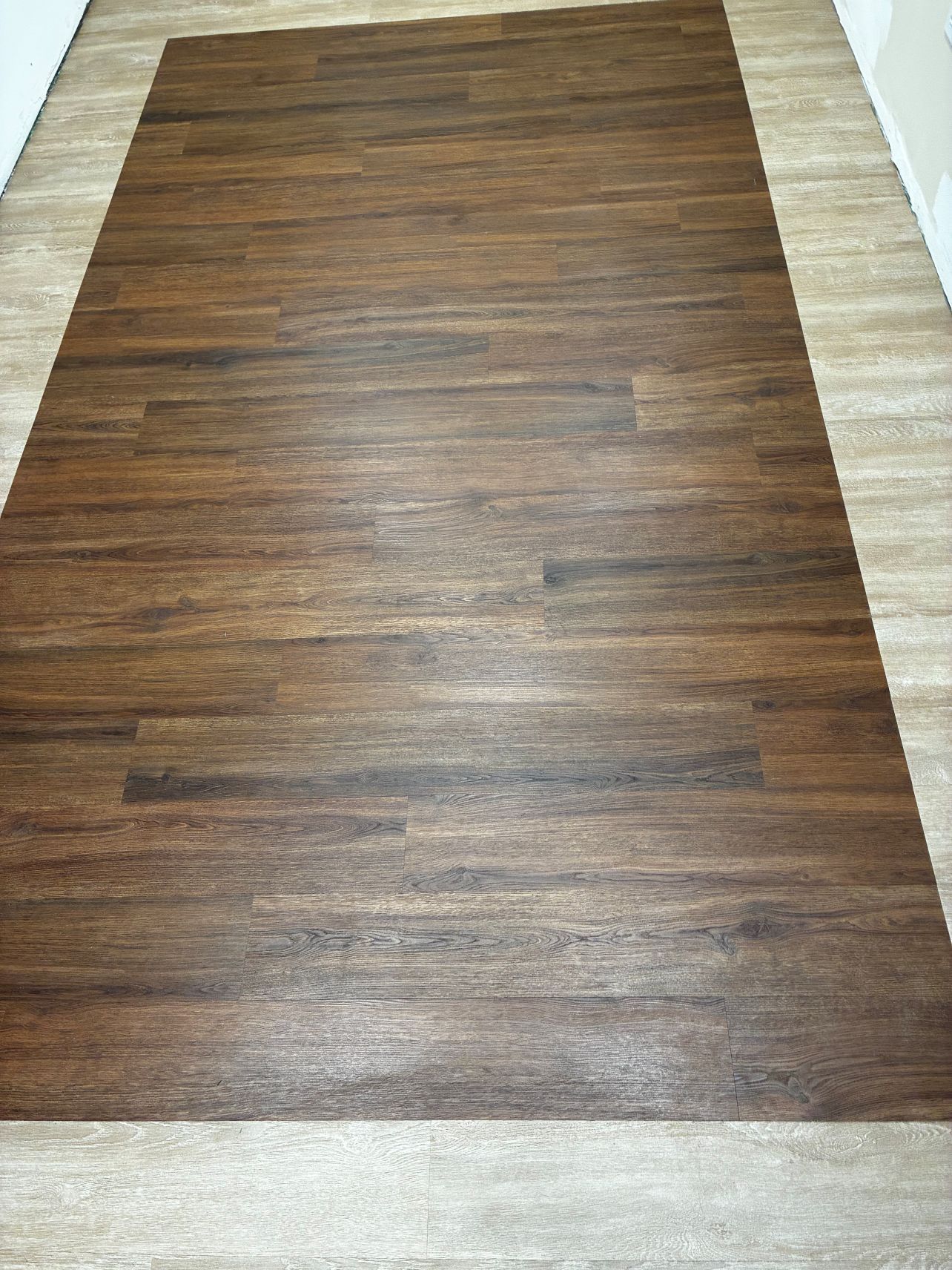 Rectangular brown wood-grain floor mat on a light tile floor