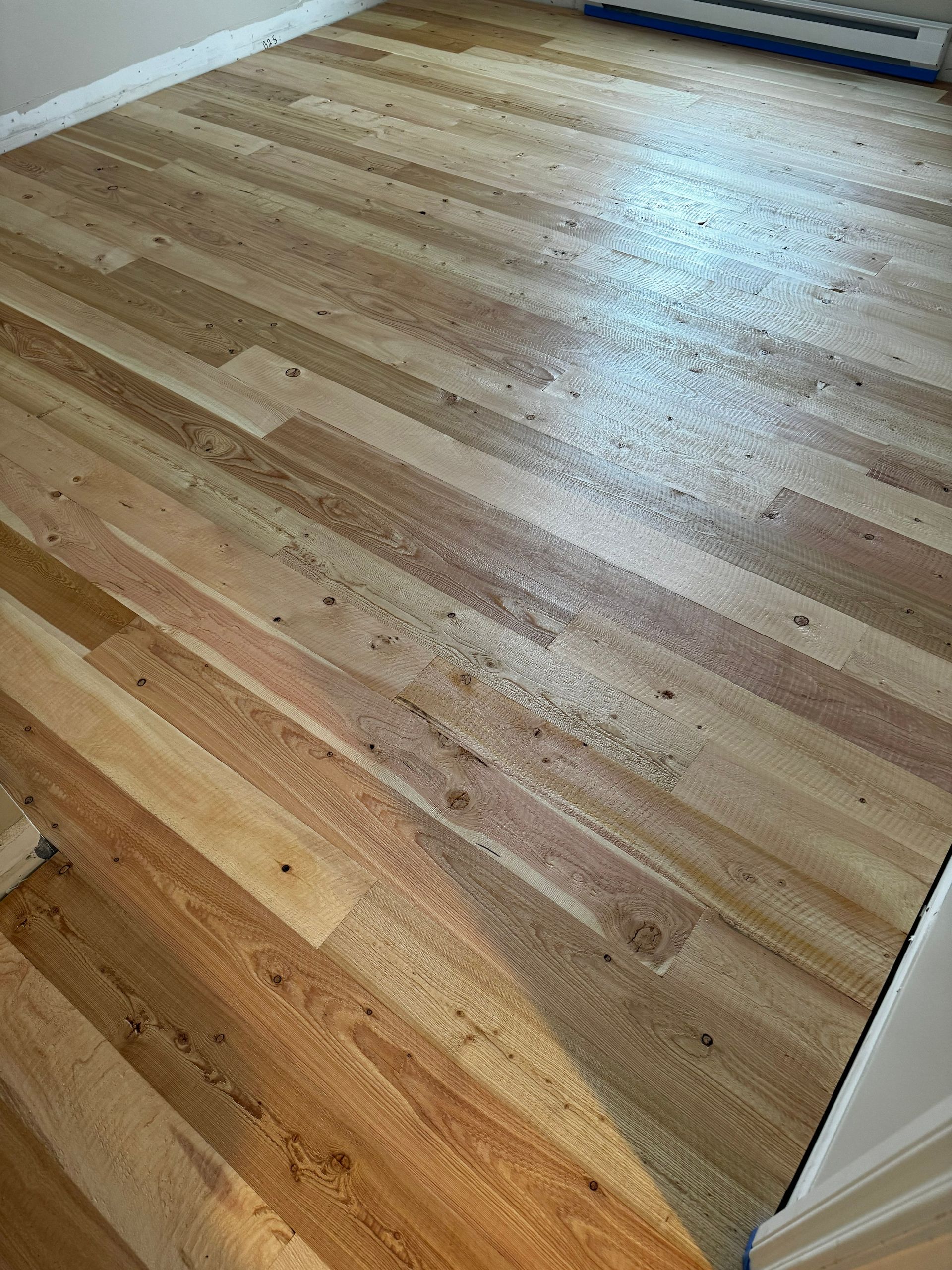 Wooden hardwood floor with visible scratches and wear in a bright room