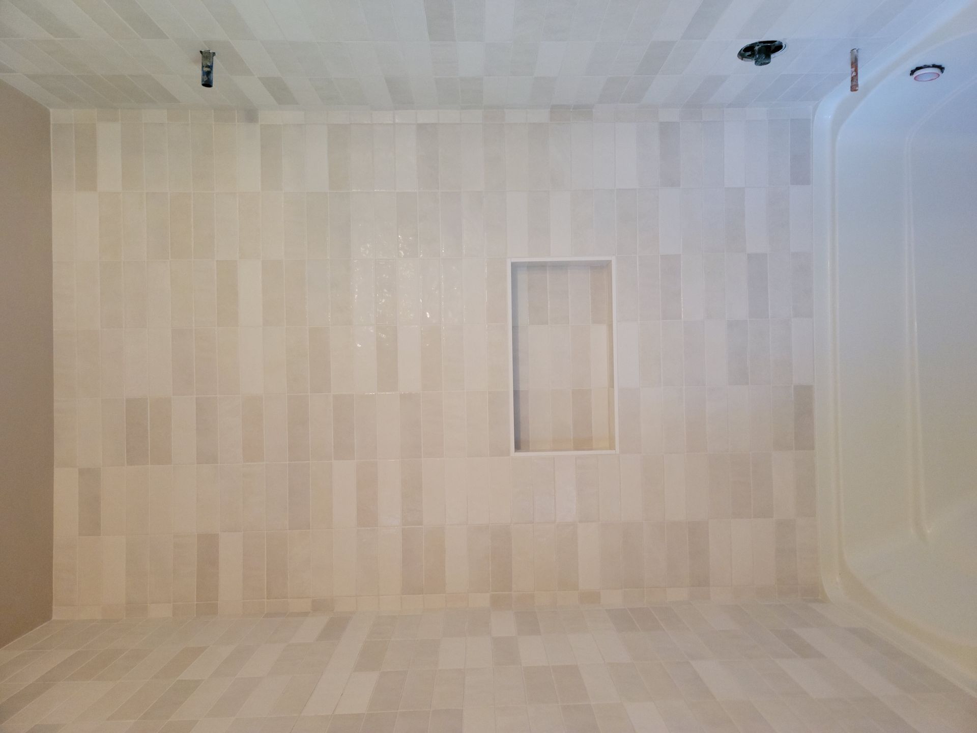 Empty light wood-paneled room with a small rectangular recessed opening on the back wall.