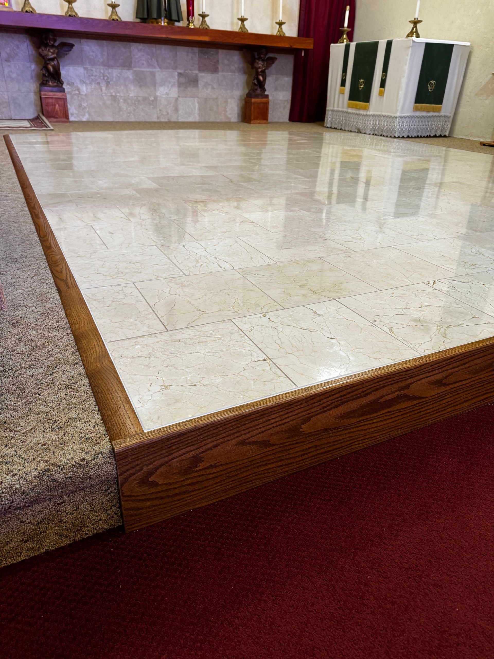 Marble-topped platform beside a carpeted floor in a room with red walls and a white appliance.