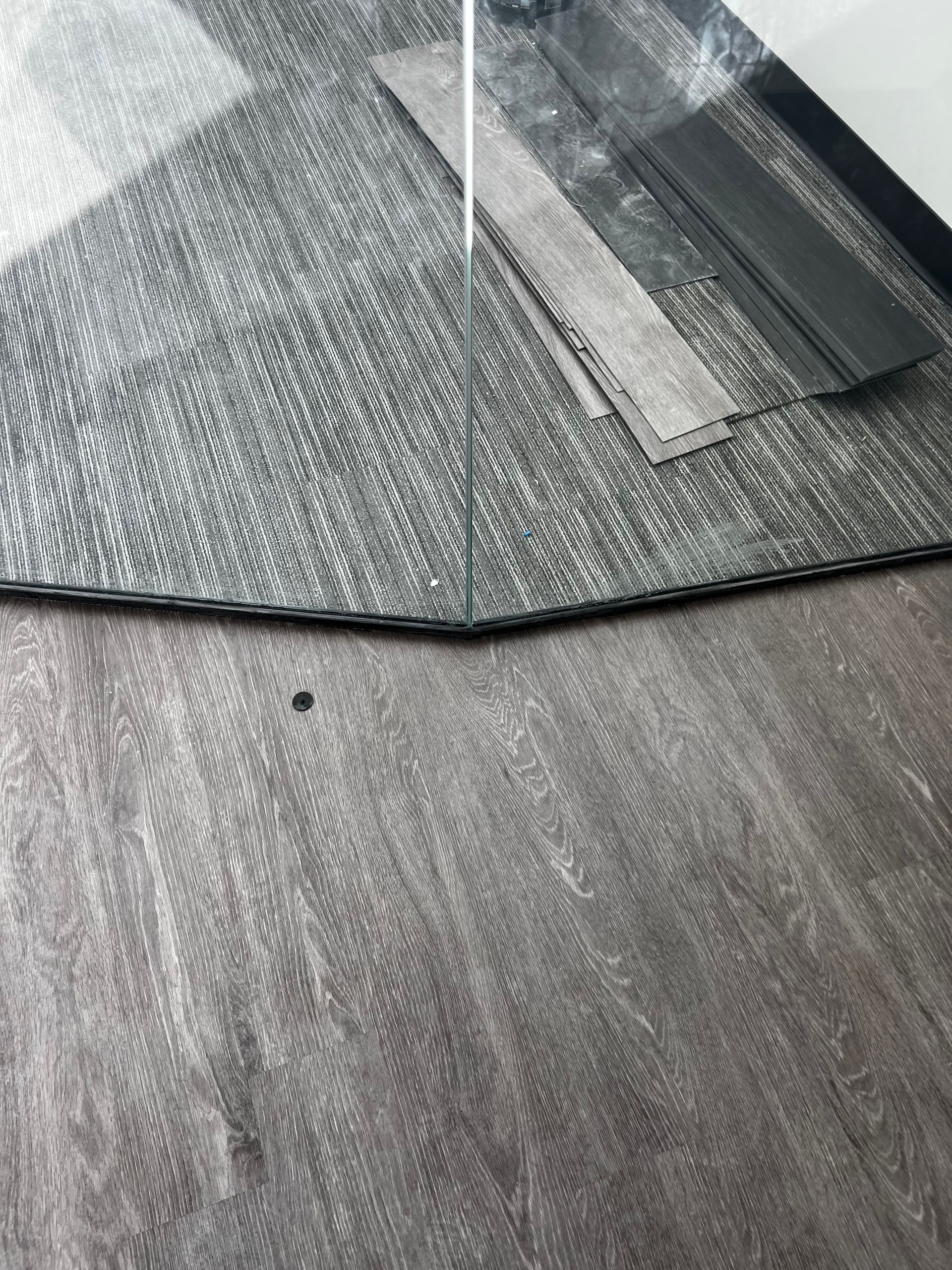 Close-up of a textured gray fabric surface with two narrow strips of tape at the top right.