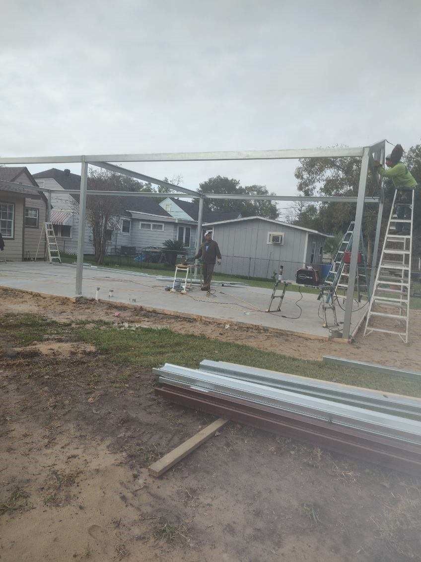 A group of people are working on a metal structure in a yard.