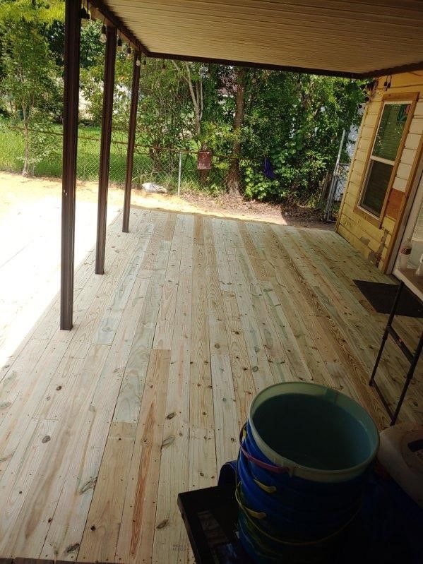 A wooden deck with a bucket of water on it.