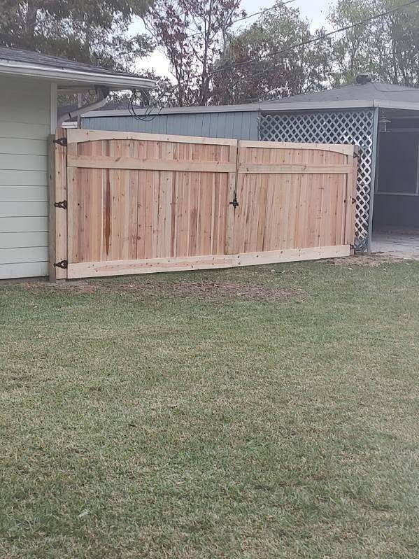 A wooden fence is in the backyard of a house.