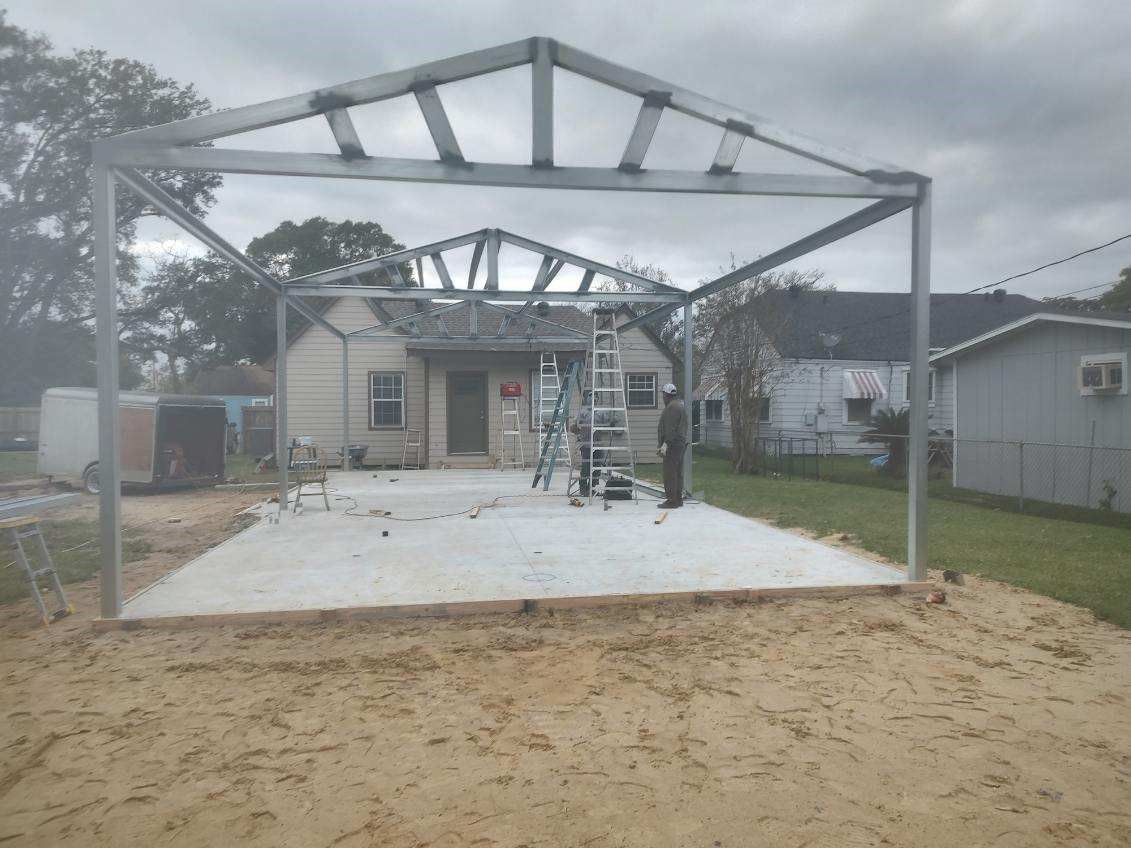 A metal structure is being built in front of a house.