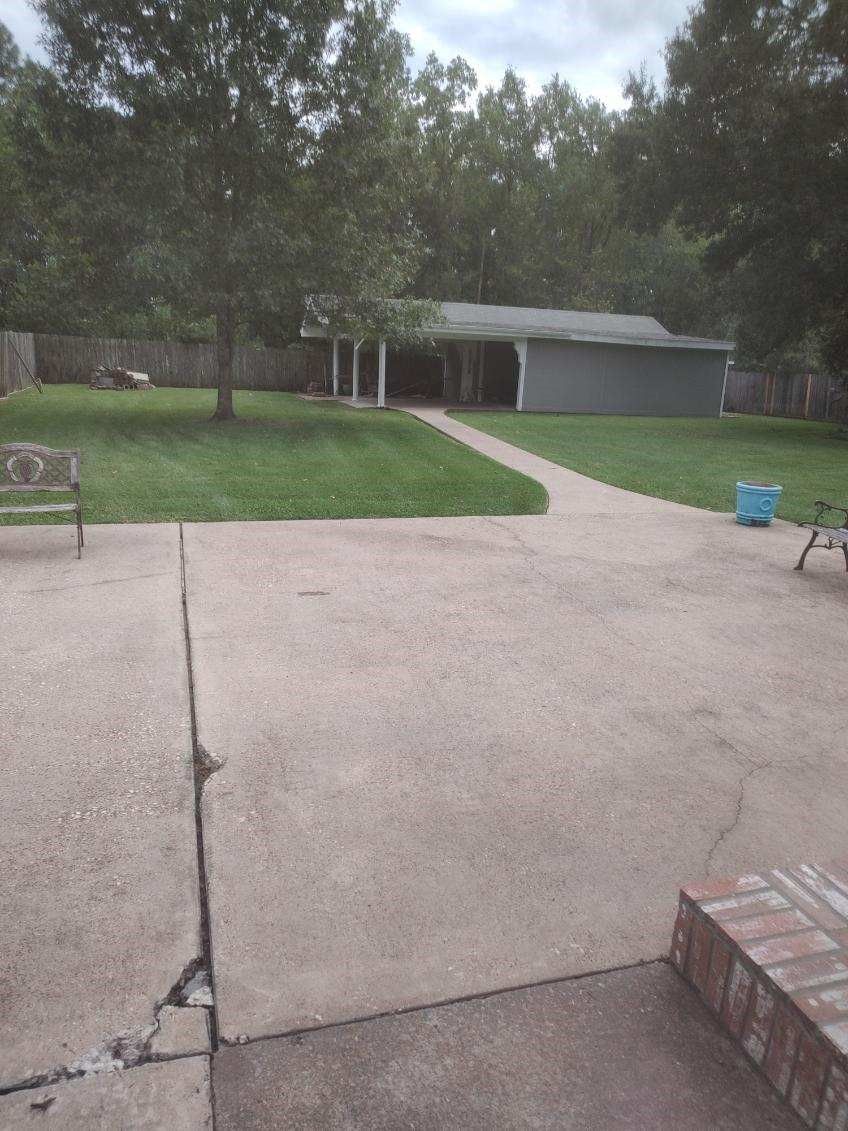 A patio with a bench and a bicycle in front of a house