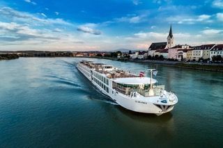 An aerial view of a cruise ship sailing down a river.