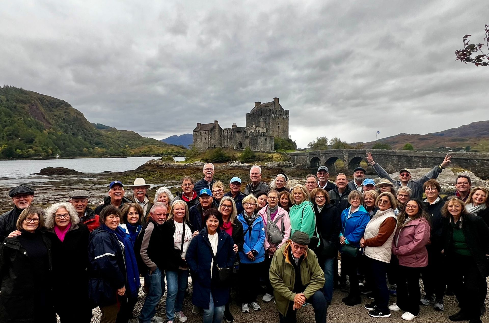 A large group of people are posing for a picture in front of a castle.