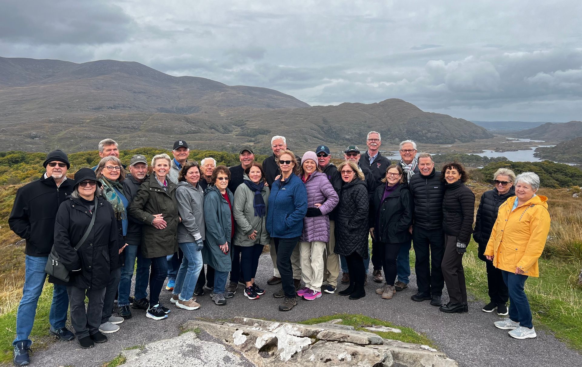 A group of people are posing for a picture on top of a hill.