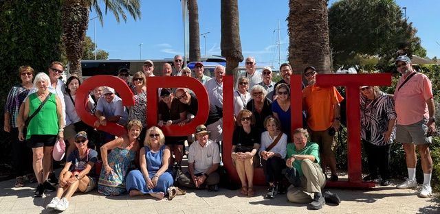 Group of people posing with a large red 