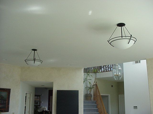 A living room with two chandeliers hanging from the ceiling