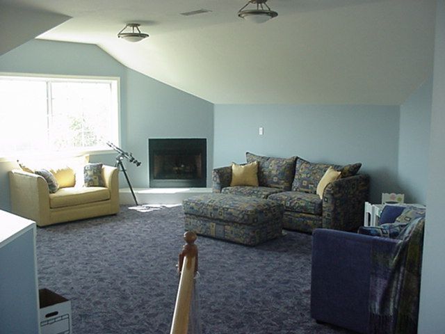 A living room with a couch and chairs and a fireplace