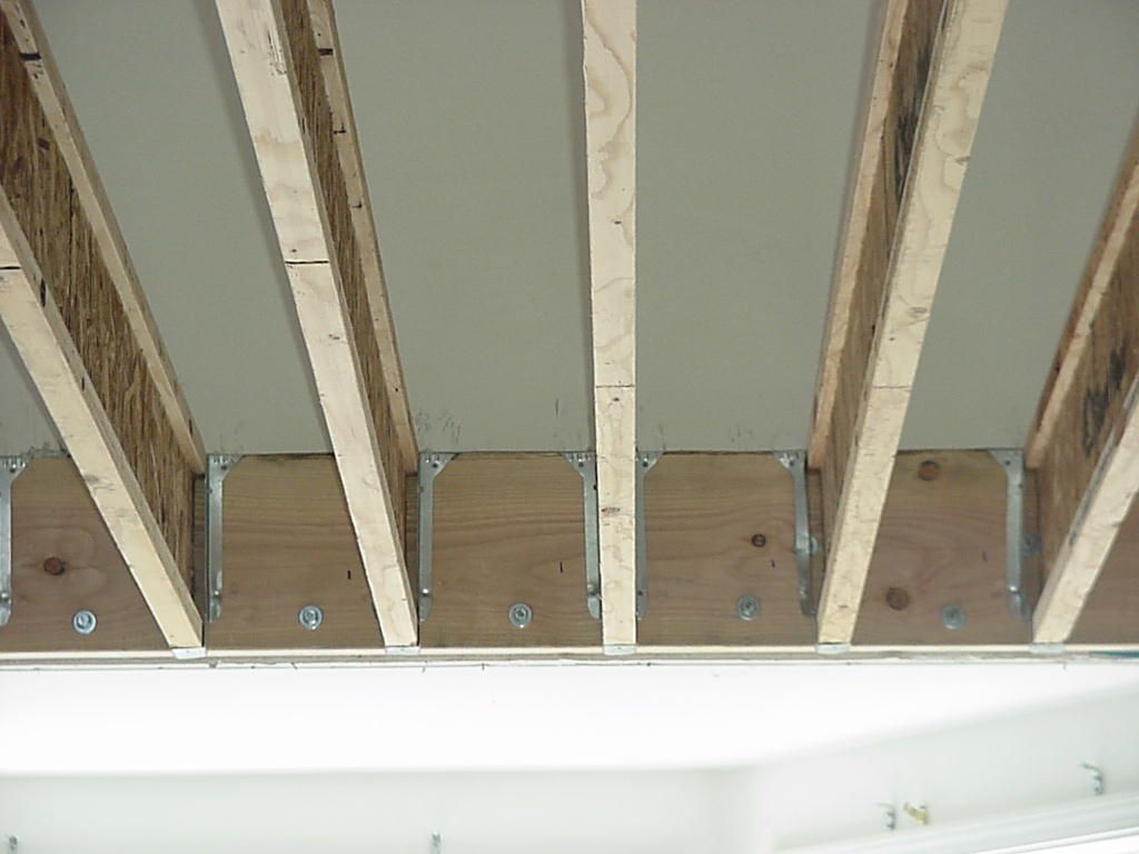 A ceiling with wooden beams and a white ceiling
