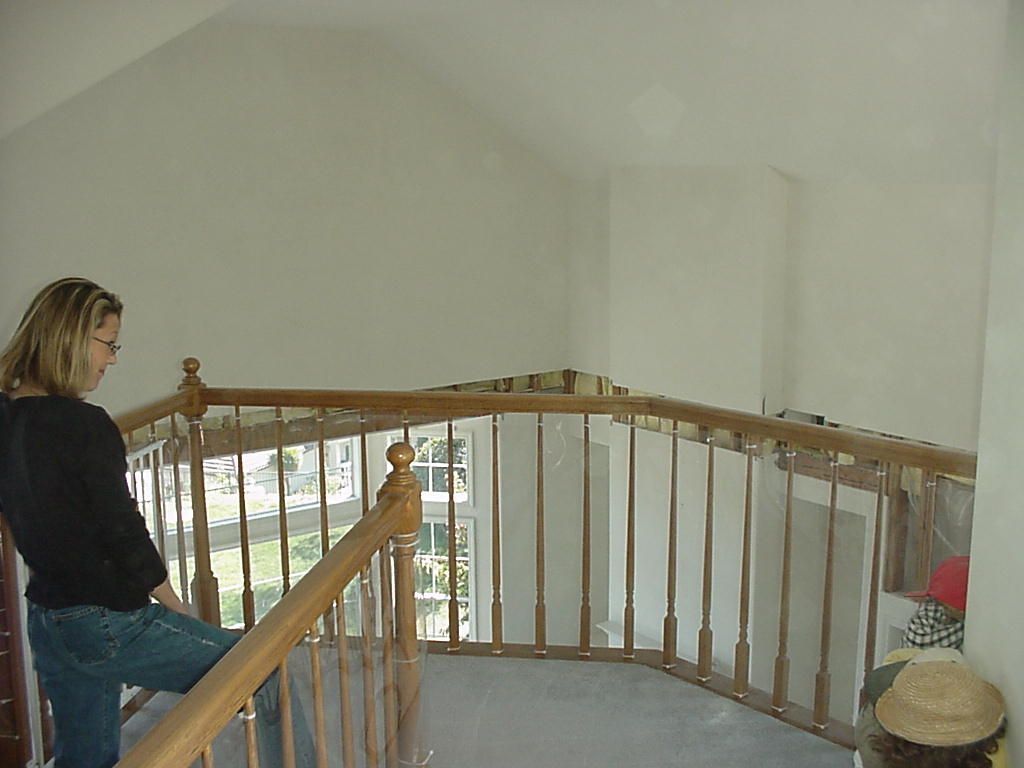 A woman leaning on a wooden railing on a staircase