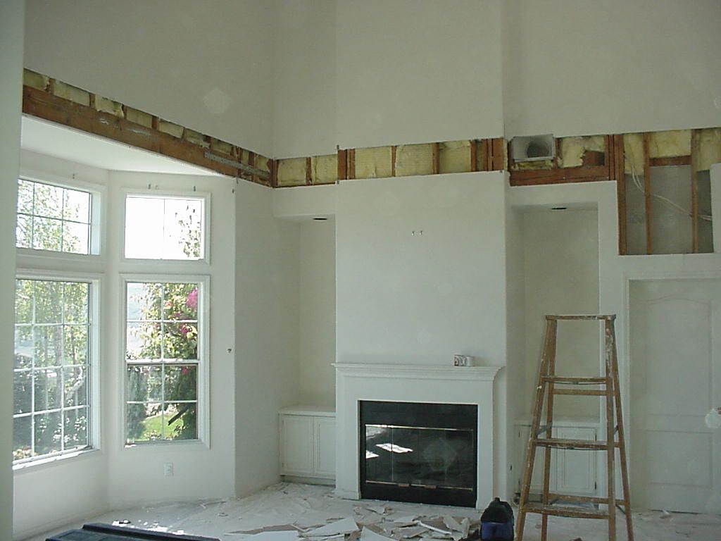 A living room with a fireplace and a ladder