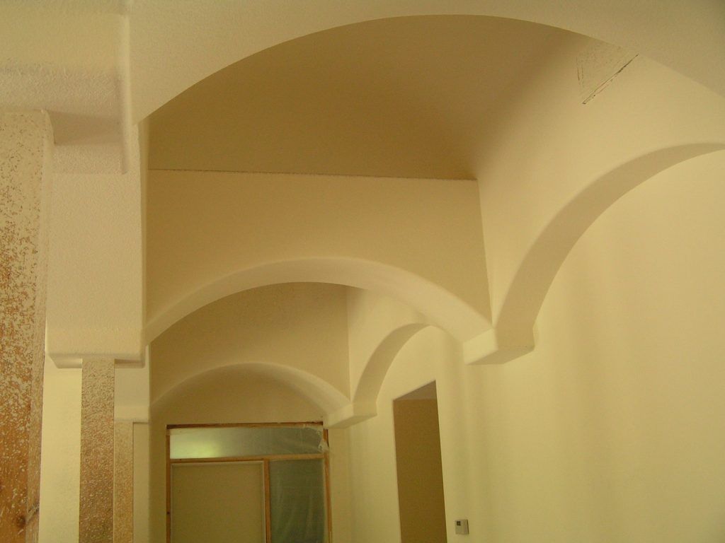 A hallway with arched ceilings and white walls.