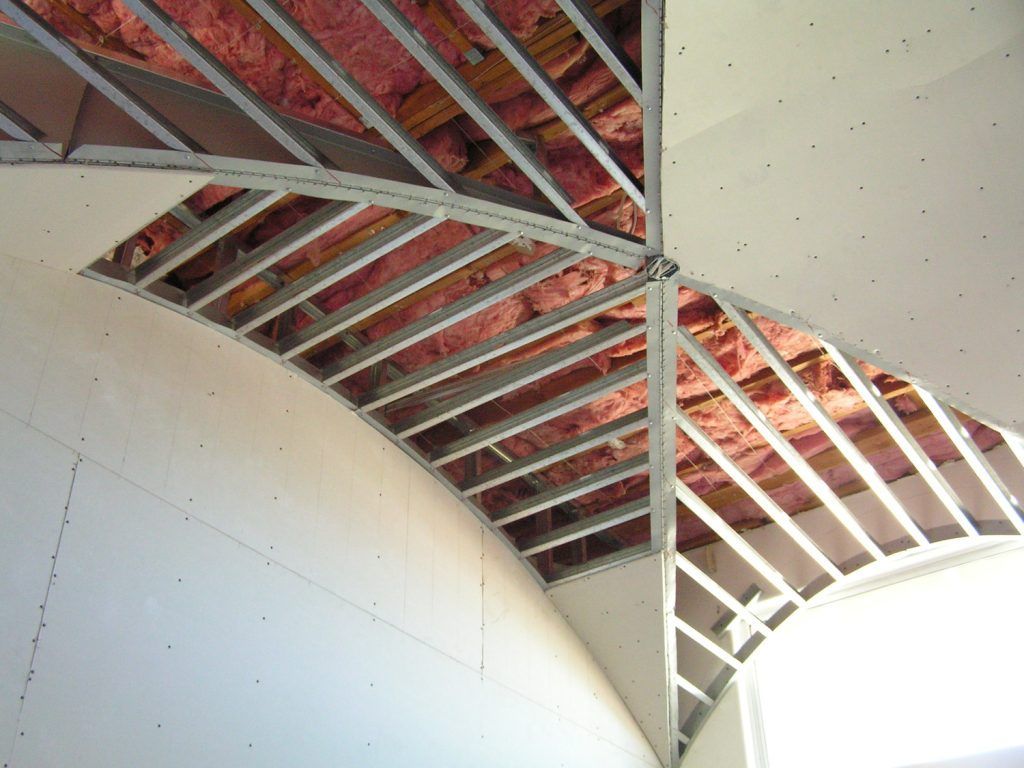The ceiling of a building is being built and has insulation on it.
