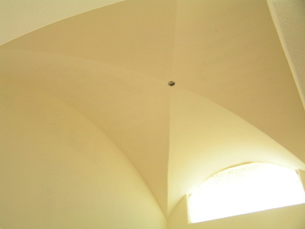 Looking up at the ceiling of a room with a window.