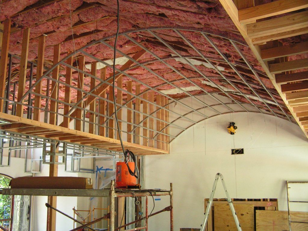 A vacuum cleaner sits on a scaffolding in a room under construction