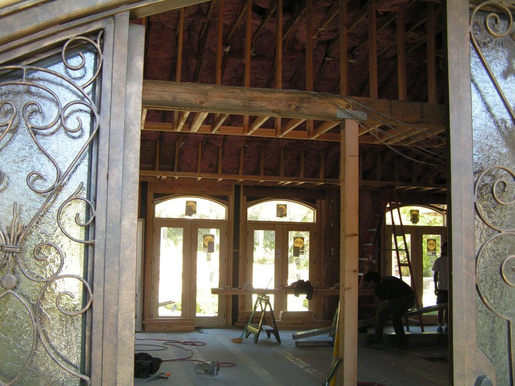 The inside of a house under construction with a wrought iron door