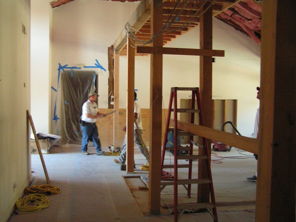 A man is working on a wooden structure in a room