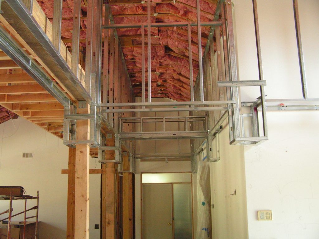 A hallway in a building under construction with a red ceiling