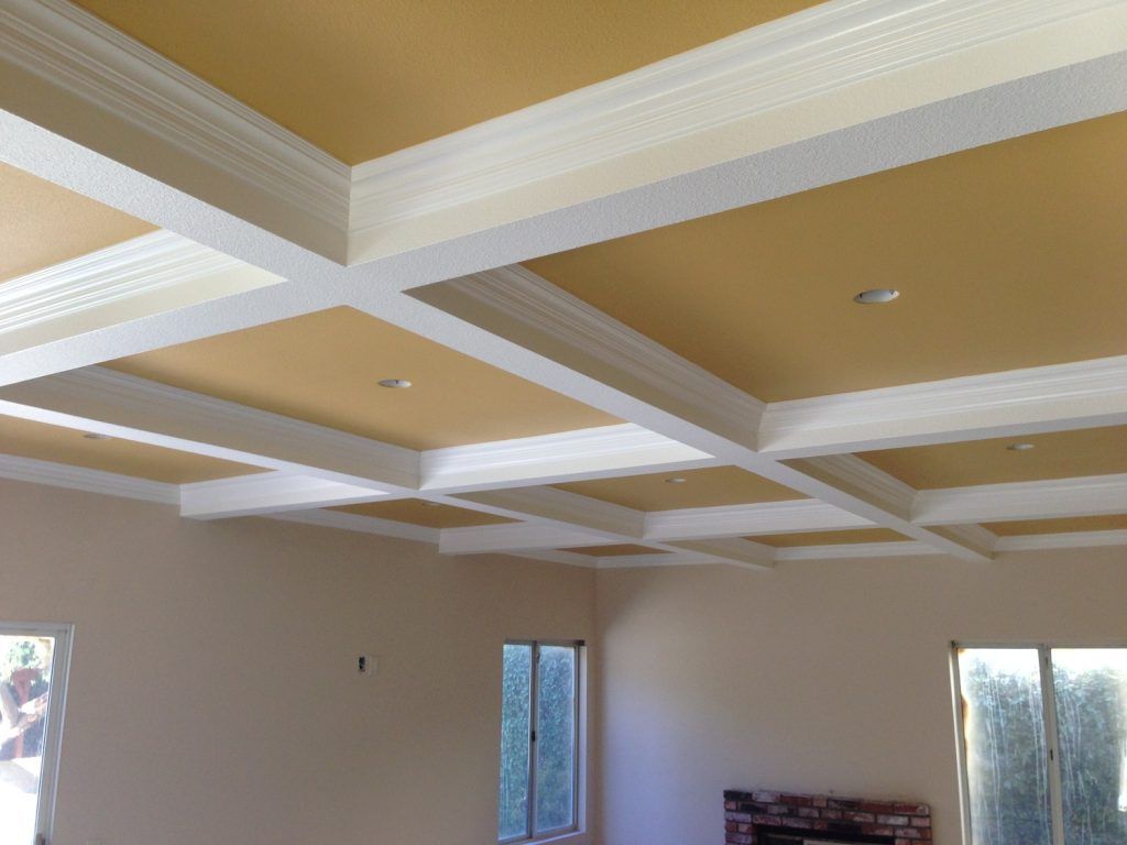 A living room with a coffered ceiling and white trim