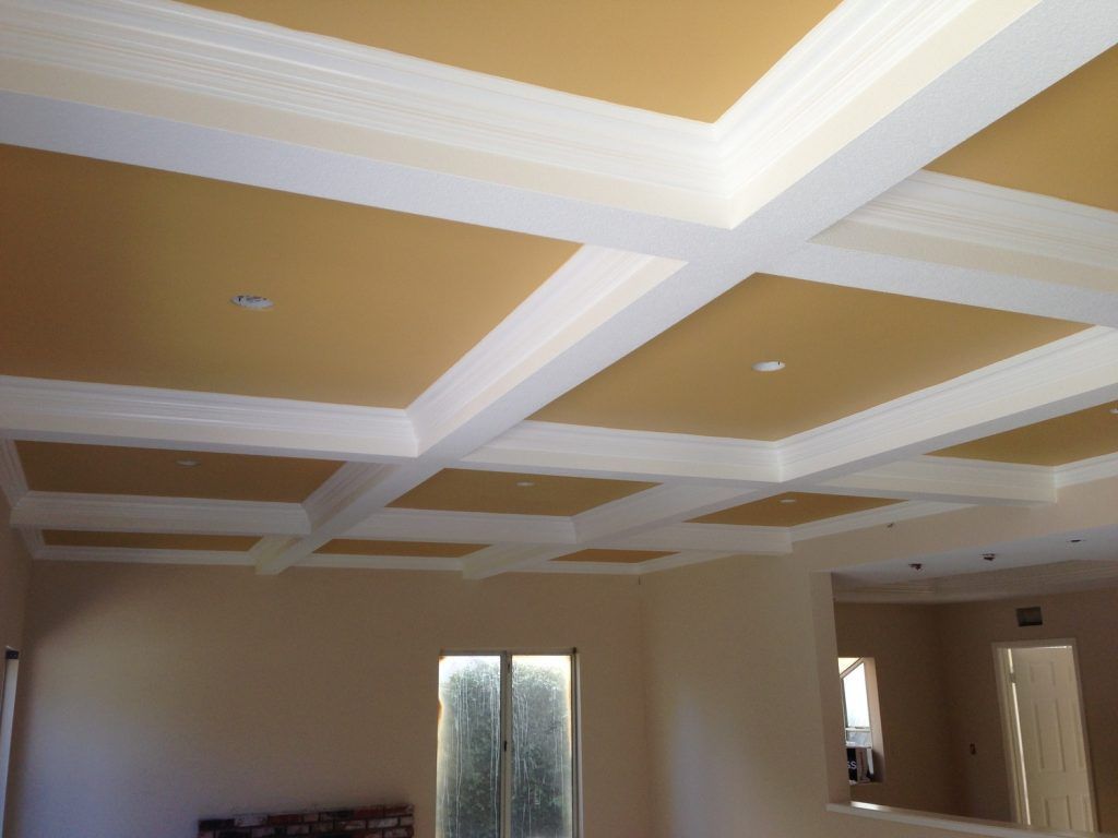 A living room with a coffered ceiling and white trim