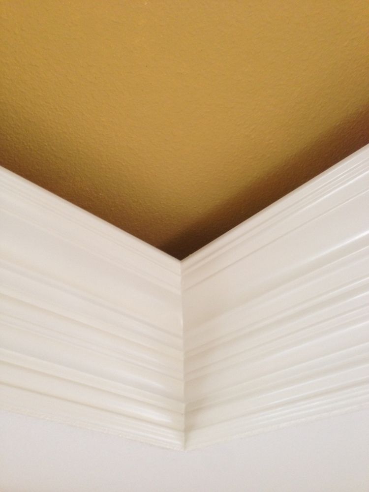 A close up of a corner of a ceiling with a white trim