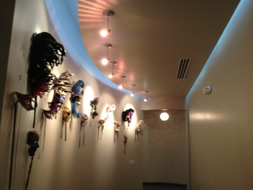 A hallway with many masks hanging on the wall