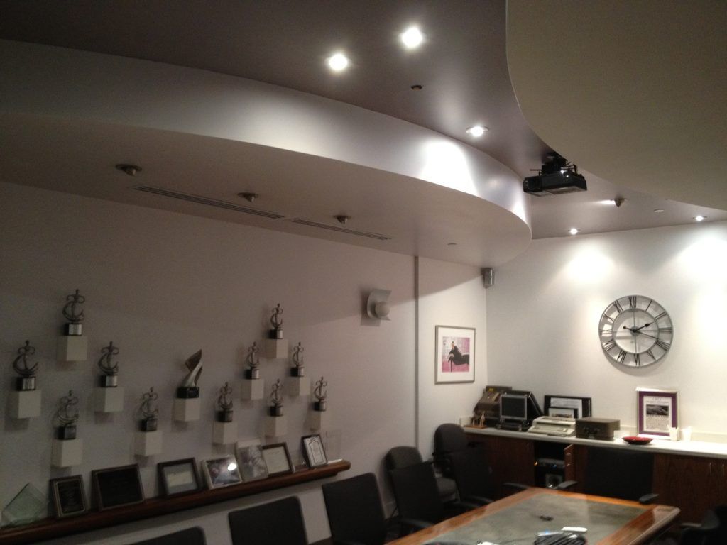 A conference room with trophies on the wall and a clock on the wall