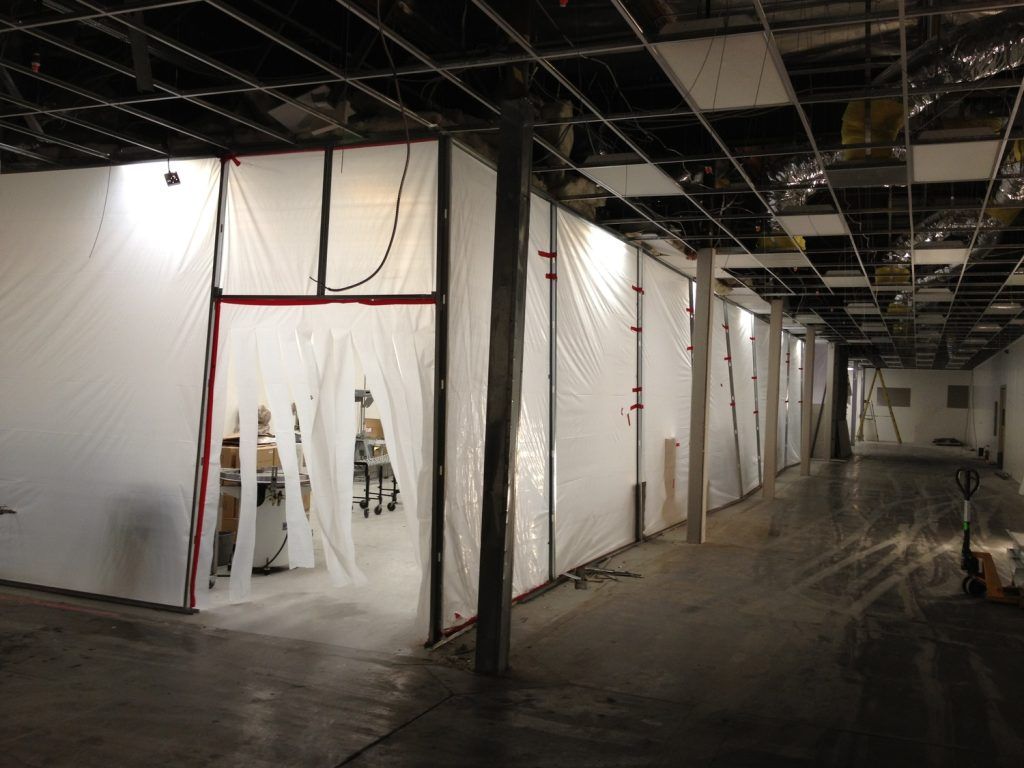 A long hallway with a lot of white tarps on the walls