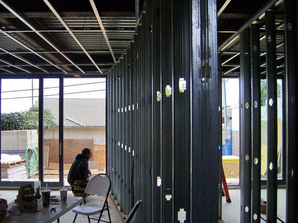 A man is sitting at a table in a room under construction.