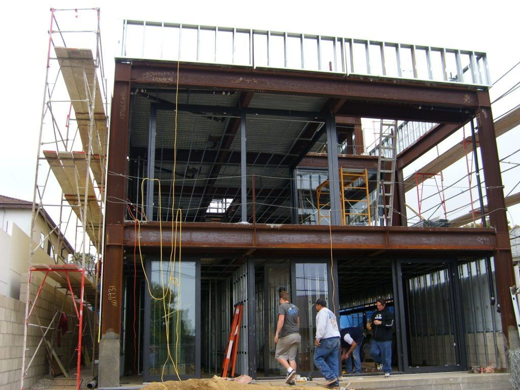 A group of men are standing in front of a building under construction.