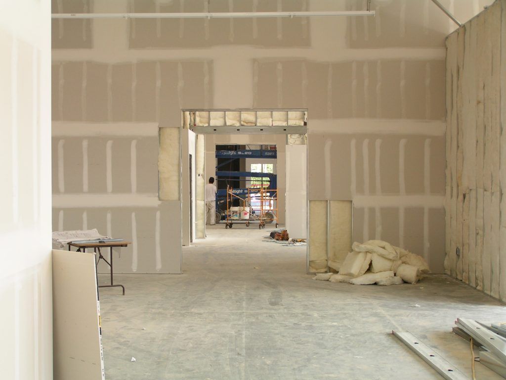 An empty room with drywall walls and a table