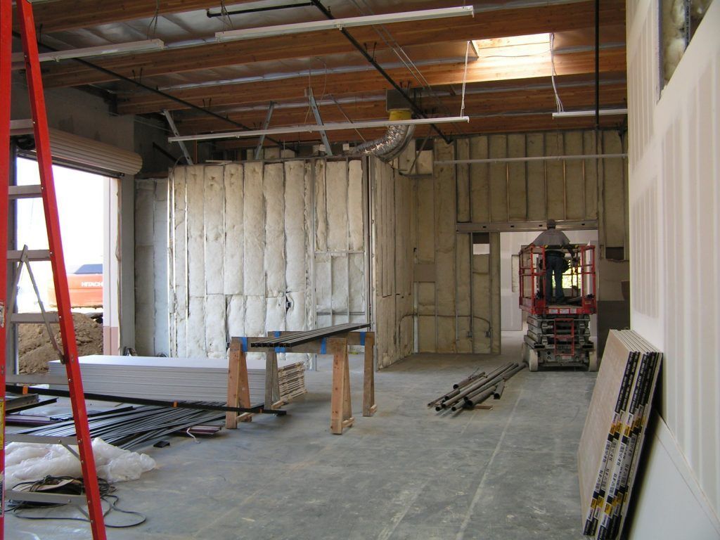 A construction site with a ladder and a man on a lift