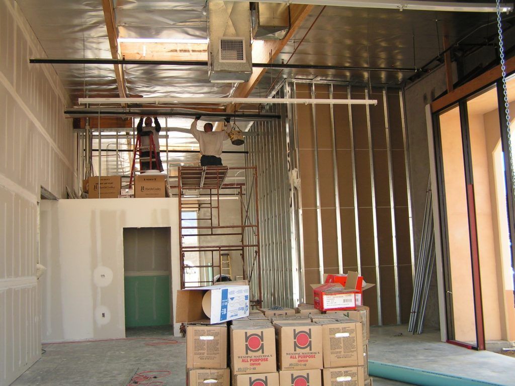 A man is standing on a scaffolding in a building under construction