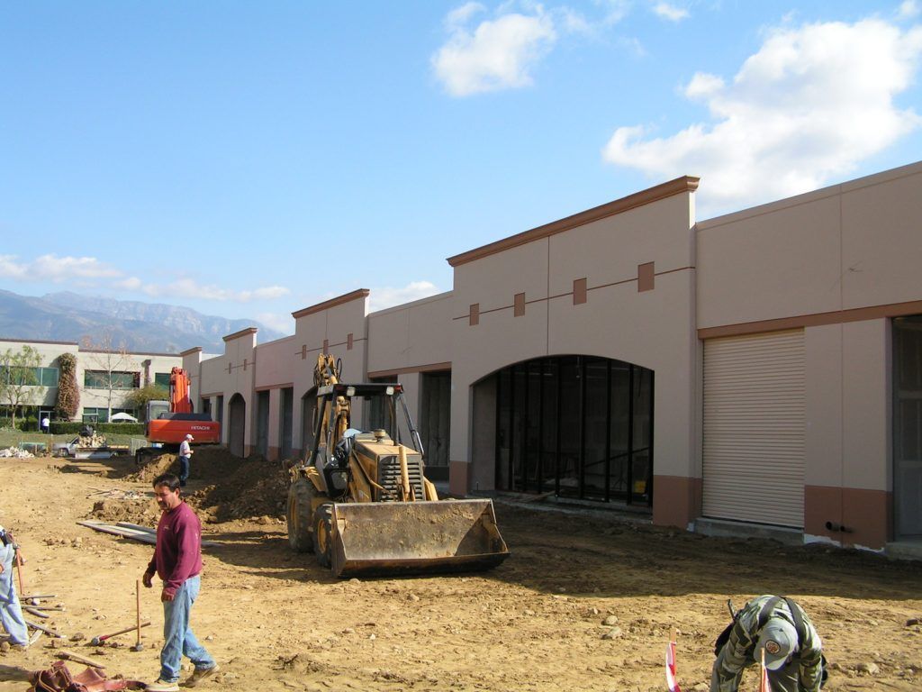 A bulldozer is parked in front of a building under construction