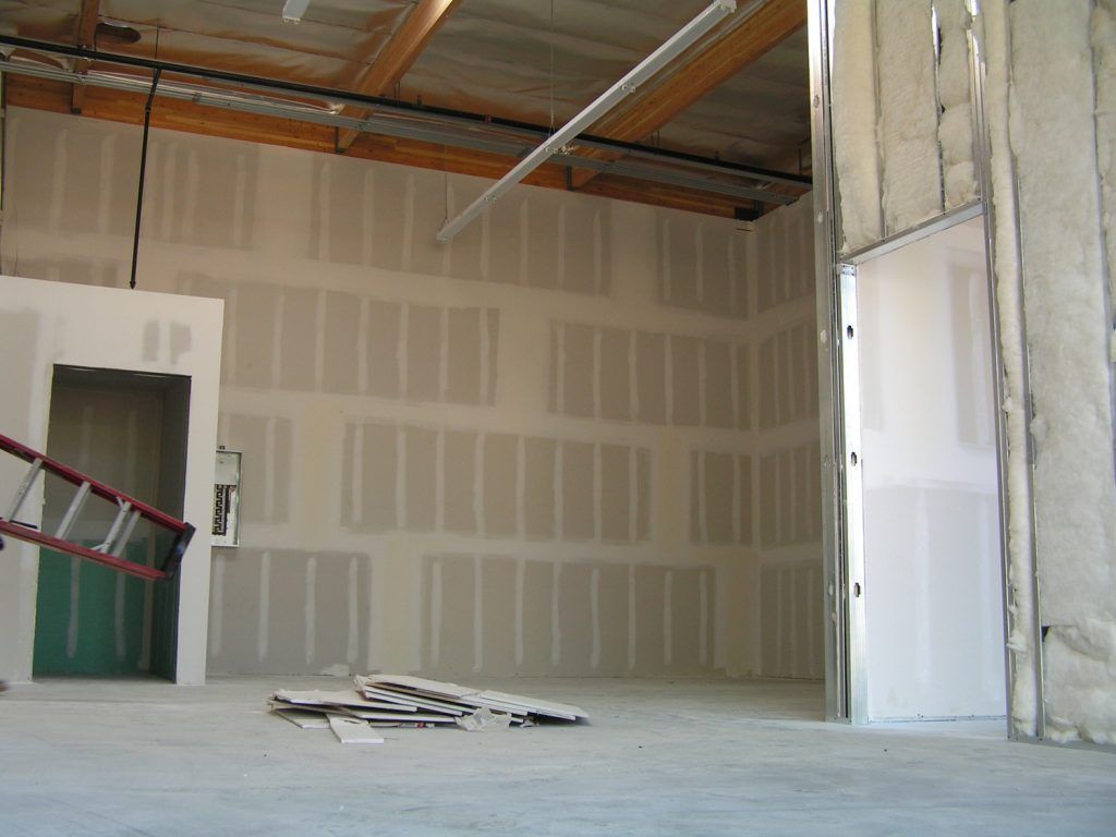An empty room with a ladder on the floor