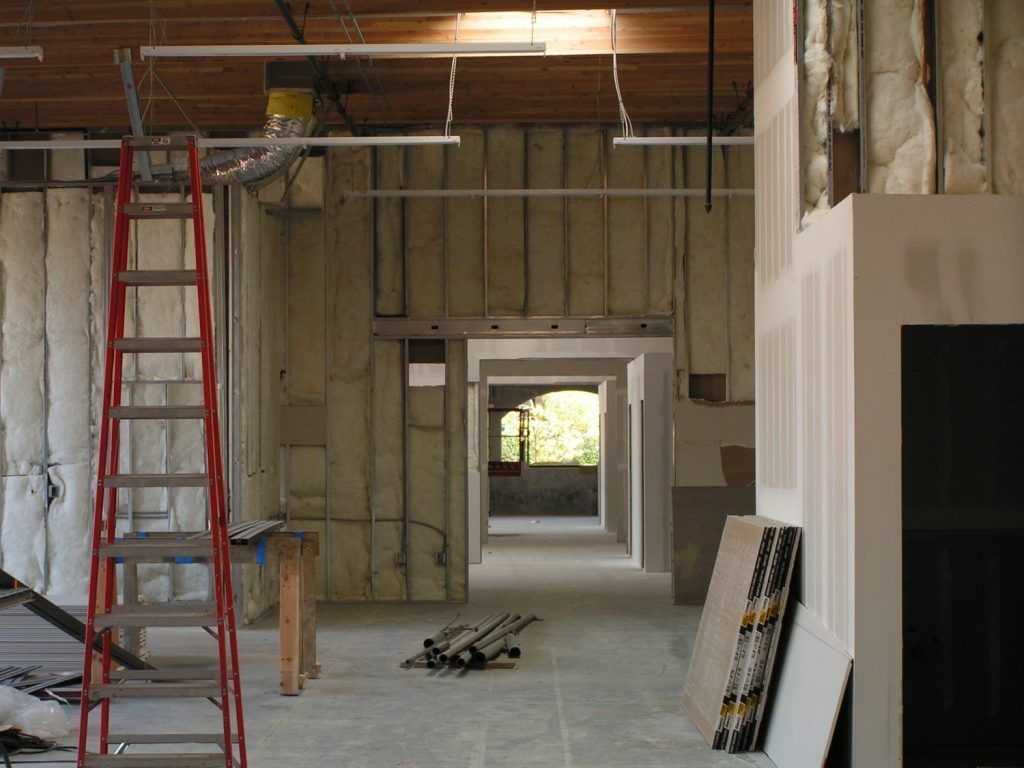 An empty room with a ladder in the middle of it