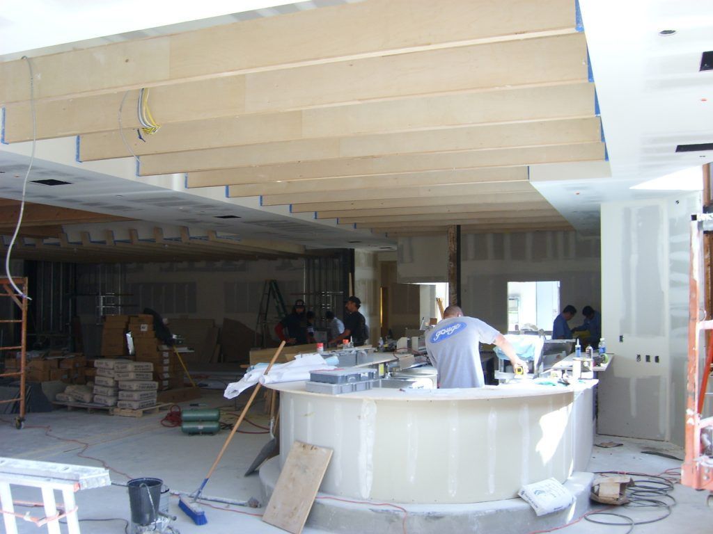 A man is working at a counter in a building under construction.