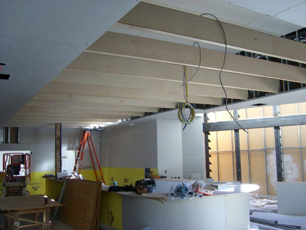 A kitchen under construction with wooden beams hanging from the ceiling