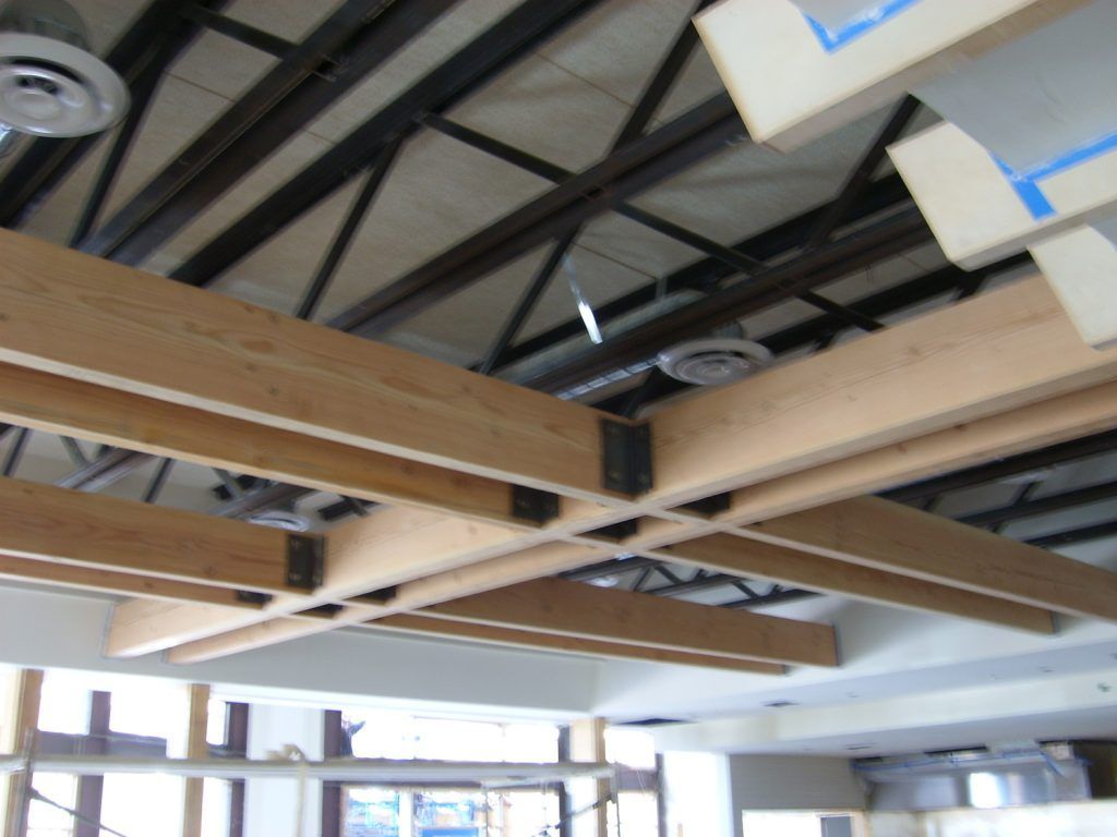 A ceiling with a lot of wooden beams and boxes hanging from it