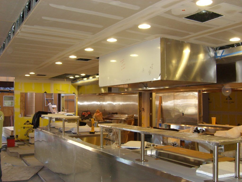 A kitchen under construction with stainless steel appliances