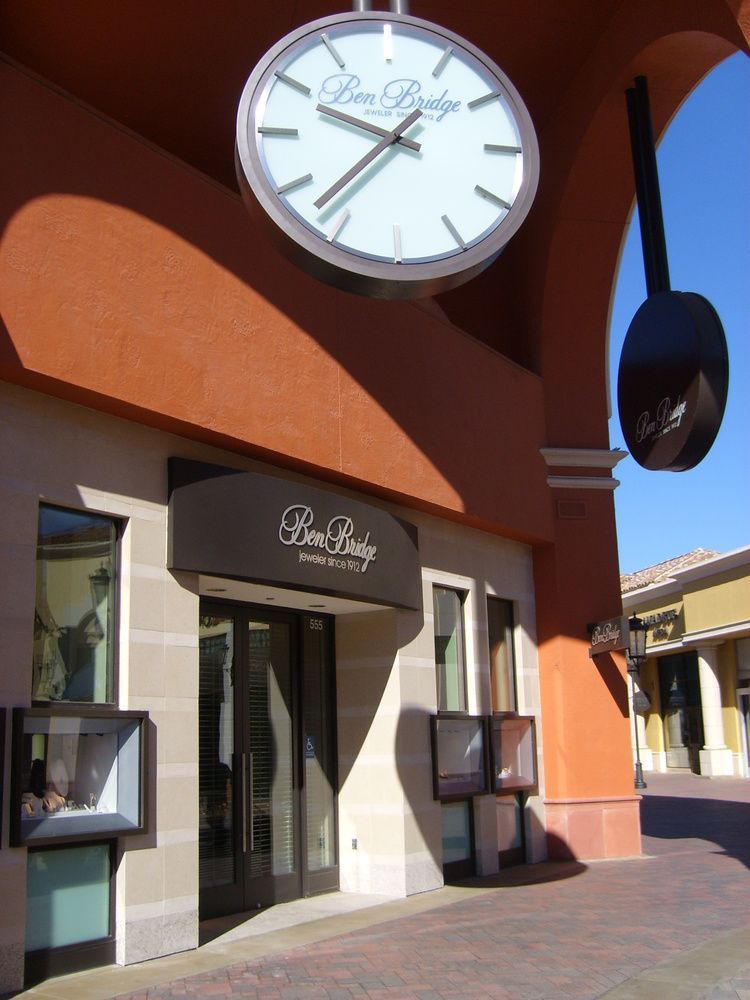 A store front with a clock above it that says ben bridge