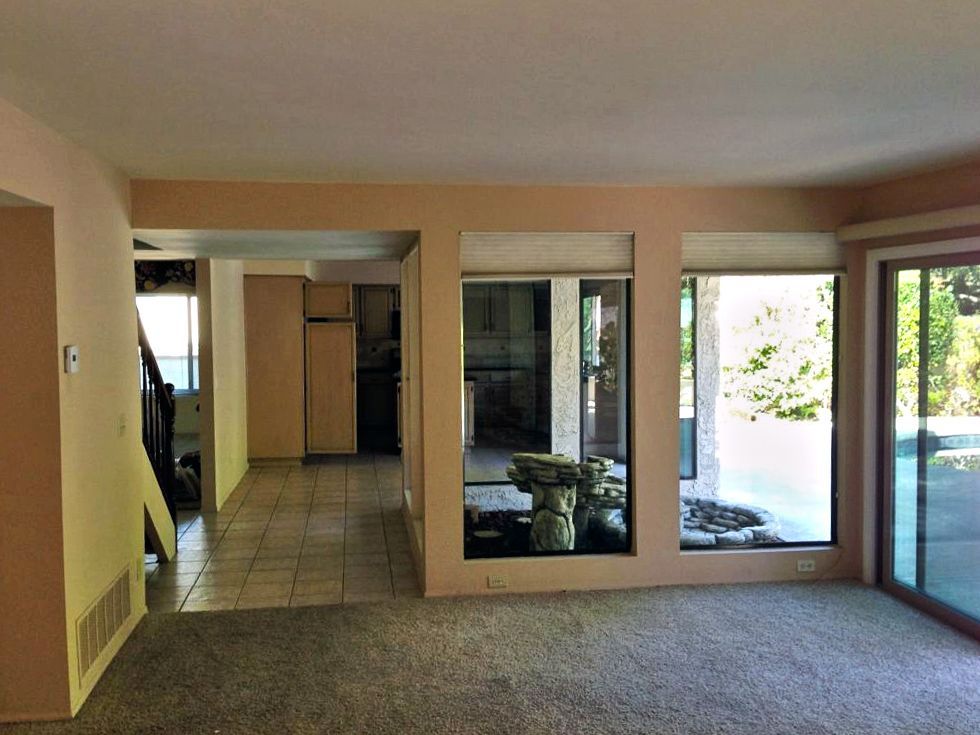 An empty living room with a sliding glass door